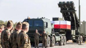 Польські військові біля пускової установки Patriot з прапором Польщі