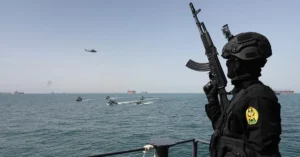 Іранський військовий спостерігає за катерами в Ормузькій протоці під час ескалації